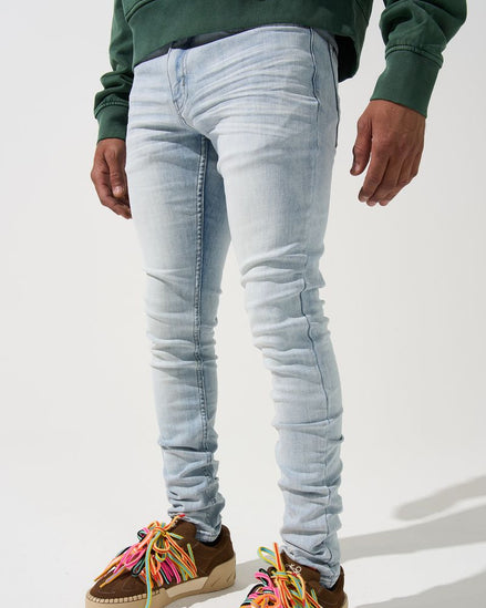 Person wearing light blue jeans and colorful sneakers on a white background