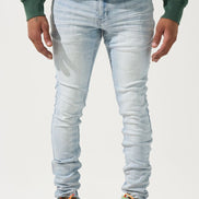 Person wearing light blue jeans and colorful sneakers on a white background