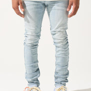 Person wearing light blue jeans and white sneakers on a white background