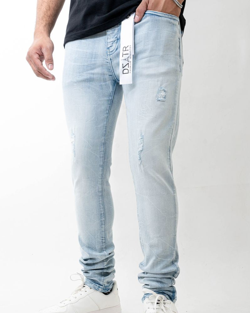 Light blue jeans with brand logo worn by a person on a white background