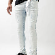 Person wearing light blue jeans with a brand logo on a white background