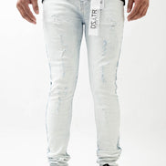 Person wearing light blue jeans with a brand label on a white background