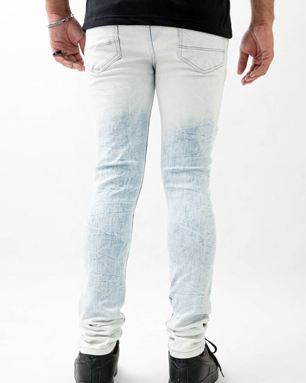 Person wearing light blue distressed jeans on a white background