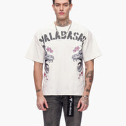 Man wearing a white t-shirt with graphic designs and text, standing against a white background
