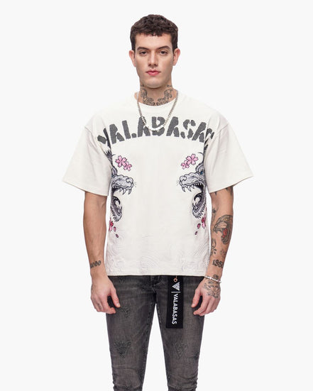 Man wearing a white t-shirt with graphic designs and text, standing against a white background