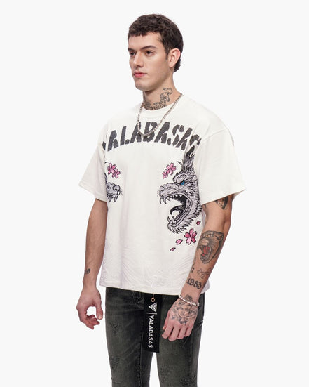 Man wearing a white t-shirt with graphic designs and text, standing against a white background