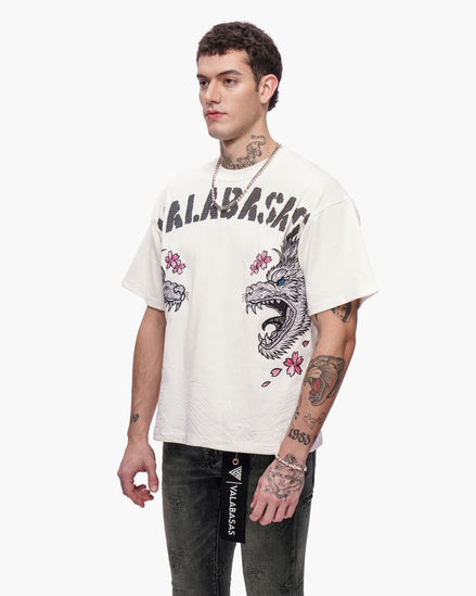 Man wearing a white t-shirt with graphic designs and text, standing against a white background