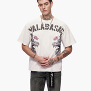 Person wearing a white t-shirt with graphic designs and text, standing against a white background