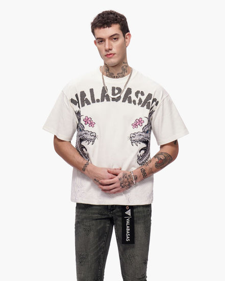 Person wearing a white t-shirt with graphic designs and text, standing against a white background