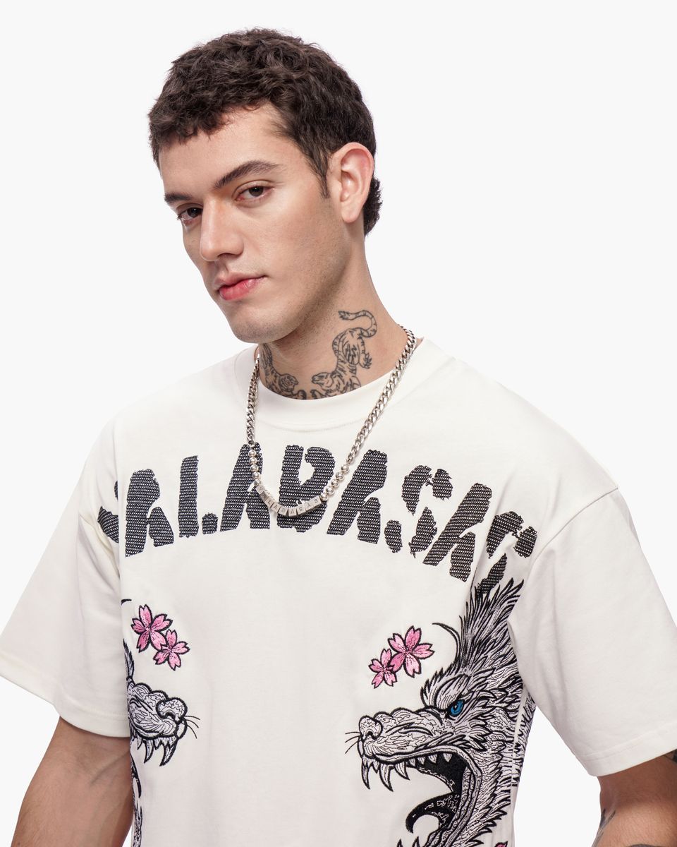 Man wearing a white t-shirt with graphic designs and text