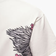 White t-shirt with black feather and pink flower design on a white background
