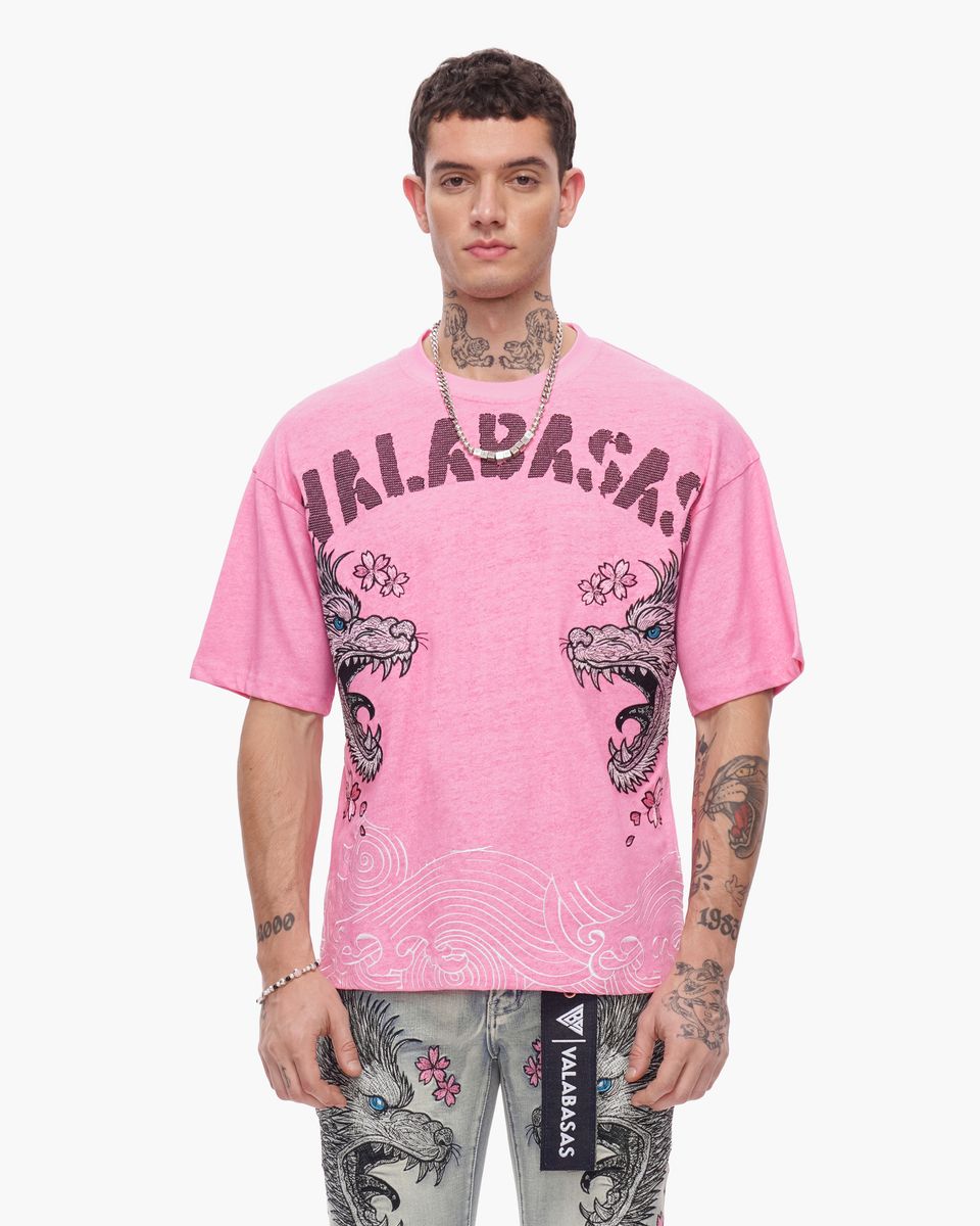 Person wearing a pink t-shirt with 'Valabash' branding and dragon design on a white background