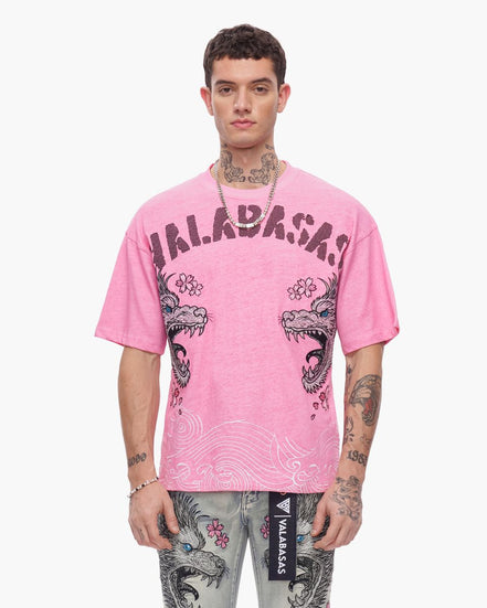 Person wearing a pink t-shirt with 'Valabash' branding and dragon design on a white background