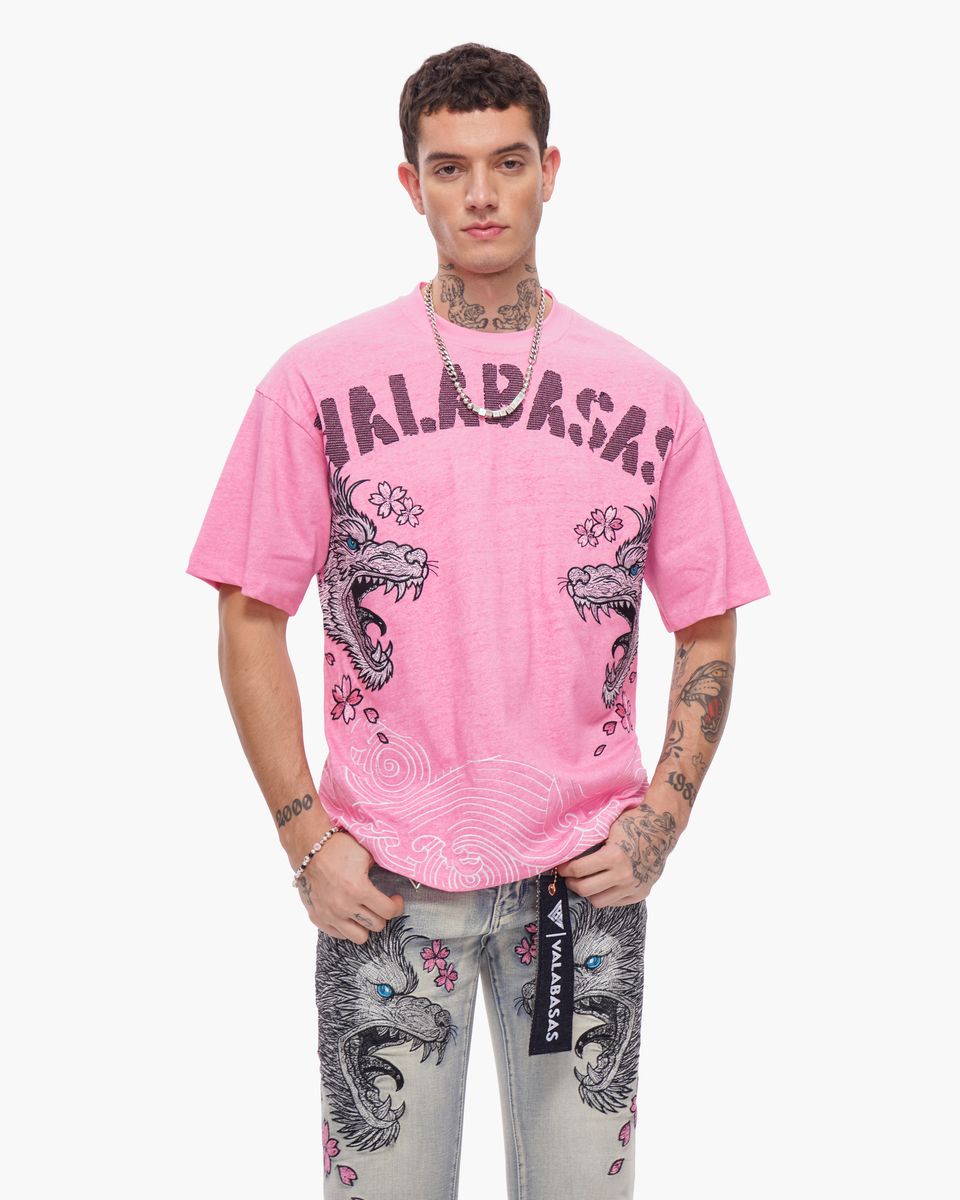 Person wearing a pink t-shirt with graphic designs on a white background