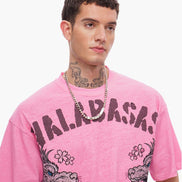 Person wearing a pink t-shirt with graphic designs and text