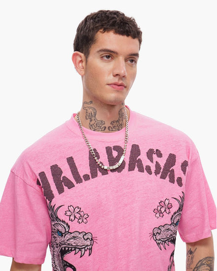 Person wearing a pink t-shirt with graphic designs and text
