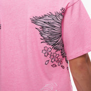 Pink t-shirt with black and white designs on a plain background