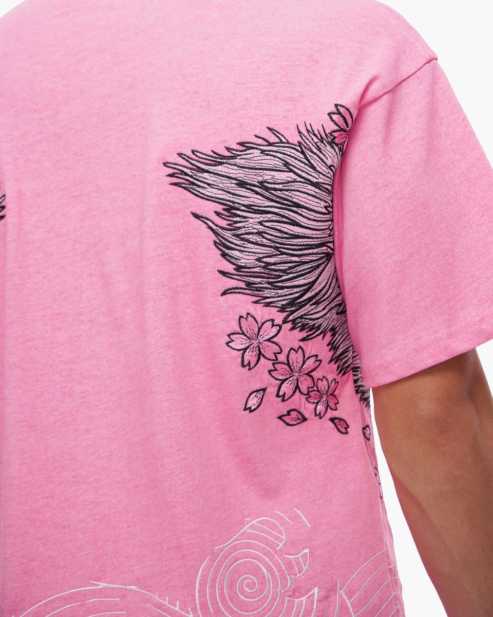 Pink t-shirt with black and white designs on a plain background