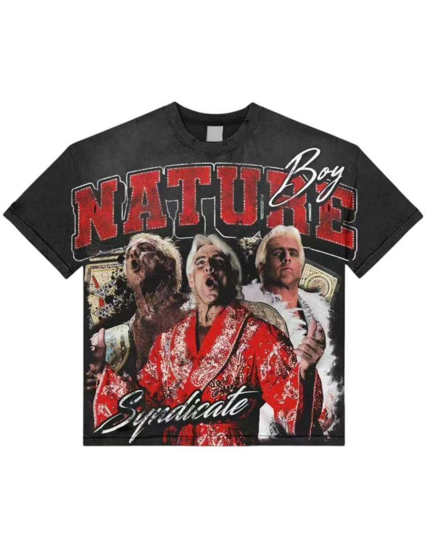 A black short-sleeve graphic T-shirt featuring a large front print with the words 'NATURE Boy Syndicate' in red and white, plus a collage-style photo graphic in red, white, and black.