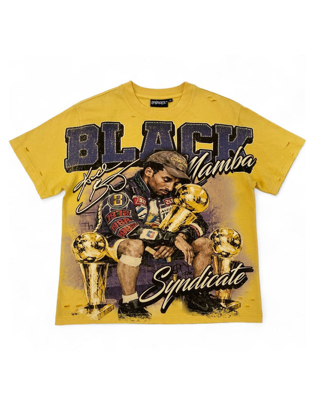 A yellow graphic t-shirt featuring a stylized illustration of Tupac Shakur sitting with four gold championship trophies, with the text 'BLACK Mamba' and 'Syndicate' printed on the front.