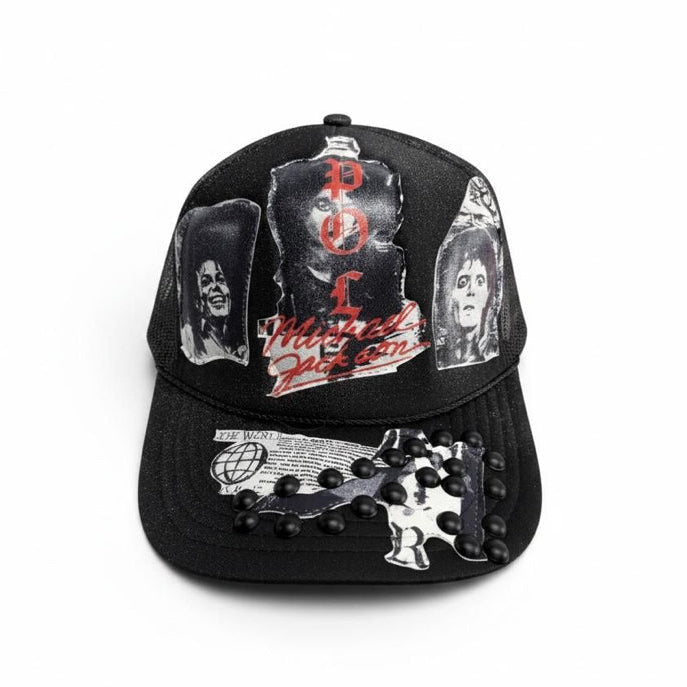 A black baseball cap featuring multiple graphic prints of Michael Jackson, including his 'Thrasher' album cover, portrait photos, and a silver-and-black guitar design embellished with black studs on the brim.