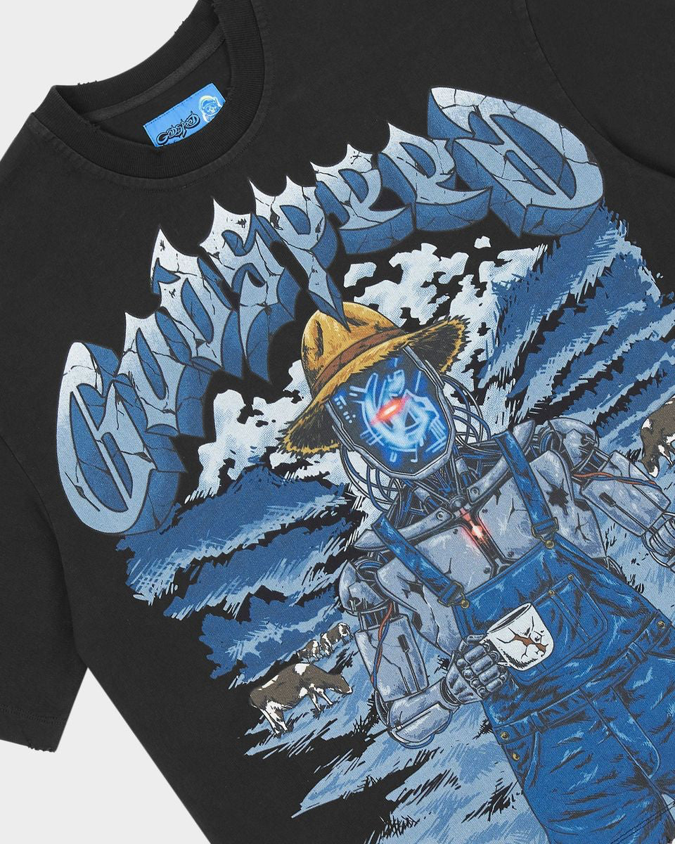A close-up of a black graphic t-shirt featuring a stylized blue and white illustration of a character in overalls and a yellow hat, with large stylized text across the chest.