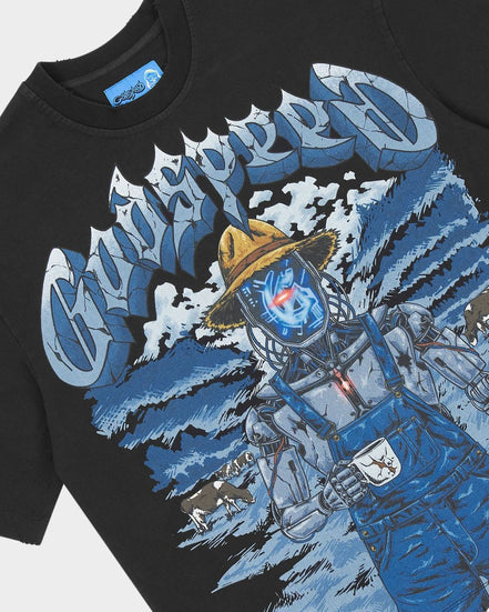 A close-up of a black graphic t-shirt featuring a stylized blue and white illustration of a character in overalls and a yellow hat, with large stylized text across the chest.