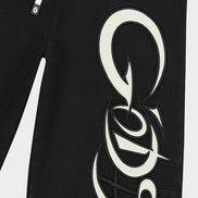 Black pants with a large white logo on a white background