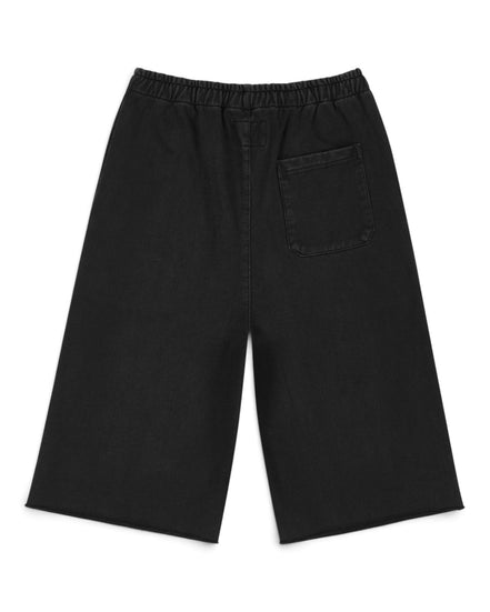 Black wide-leg shorts with an elastic waistband and a single patch pocket on the left side, shown flat on a white background.