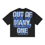 A black short-sleeve t-shirt with a large graphic text print on the front reading 'OUT OF MANY, ONE' in white letters with a blue 3D shadow effect, displayed on a solid white background.