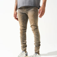 Person wearing beige jeans and white sneakers on a white background