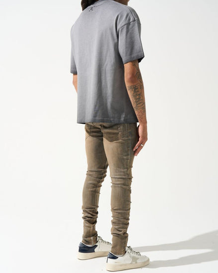 Person wearing a gray t-shirt and beige pants on a white background
