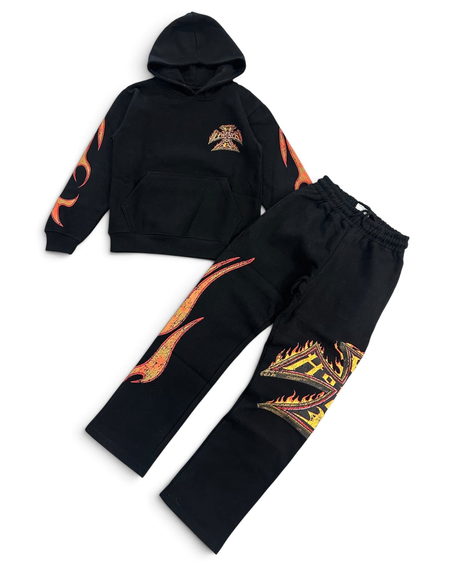 A two-piece kids' tracksuit set consisting of a black hoodie and matching sweatpants, both decorated with vibrant orange and yellow flame graphics and a small chest emblem, displayed on a clean white background.