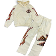 A two-piece kids' loungewear set consisting of a cream-colored cropped hoodie and matching sweatpants, both decorated with red and black flame-like graphics and a small cross emblem on the chest.