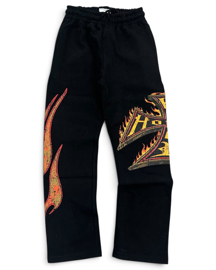 Black sweatpants featuring a large orange and yellow flame graphic on the right leg and a stylized gold and orange letter 'H' on the left leg, displayed against a plain white background.