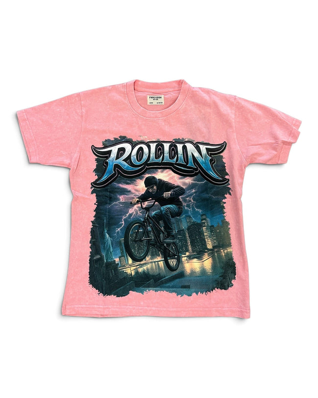 A pink short-sleeve graphic t-shirt featuring a large front print of a mountain biker with the word 'ROLLIN' in stylized blue and white lettering above, set against a plain white background.