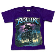A purple short-sleeve graphic t-shirt featuring a large front print of a BMX rider with the word 'ROLLIN'' in stylized metallic lettering, shown on a plain white background.