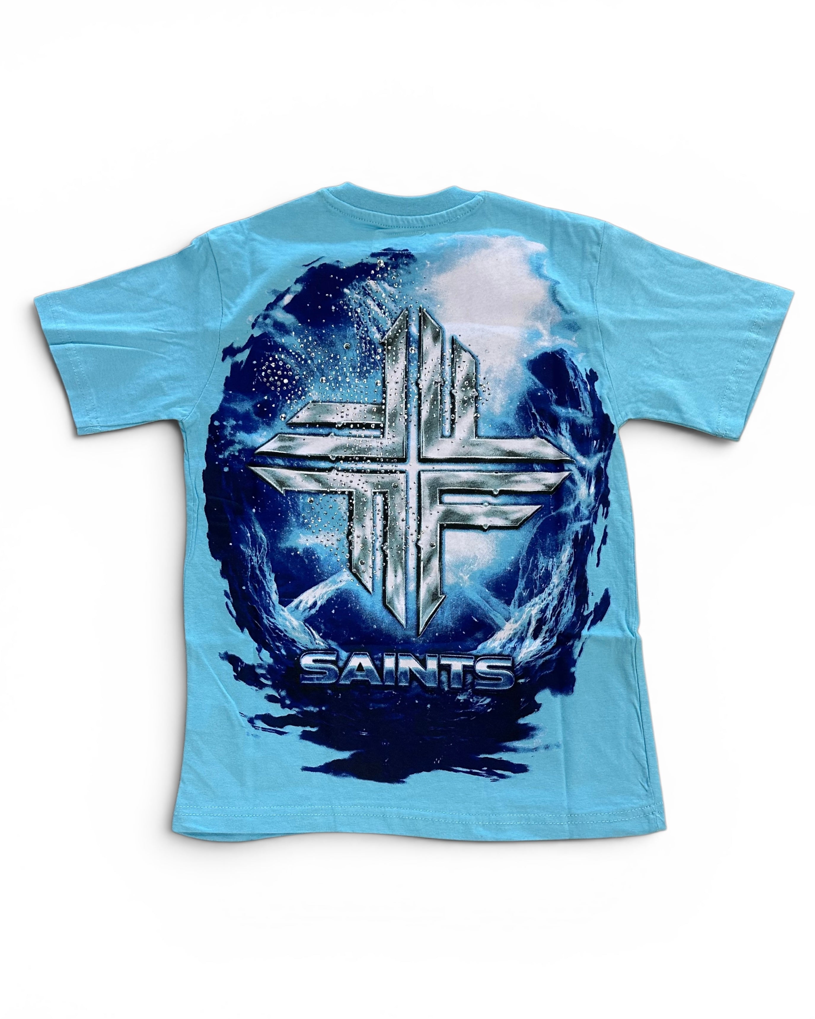 A light blue short-sleeve t-shirt with a large back graphic featuring a metallic silver cross over a dark blue and white circular design with the word 'SAINTS' underneath.