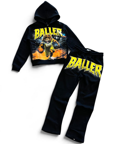 A two-piece kids' tracksuit set consisting of a black cropped hoodie and matching sweatpants, both featuring a large yellow 'BALLER' graphic and a basketball player illustration on the front.