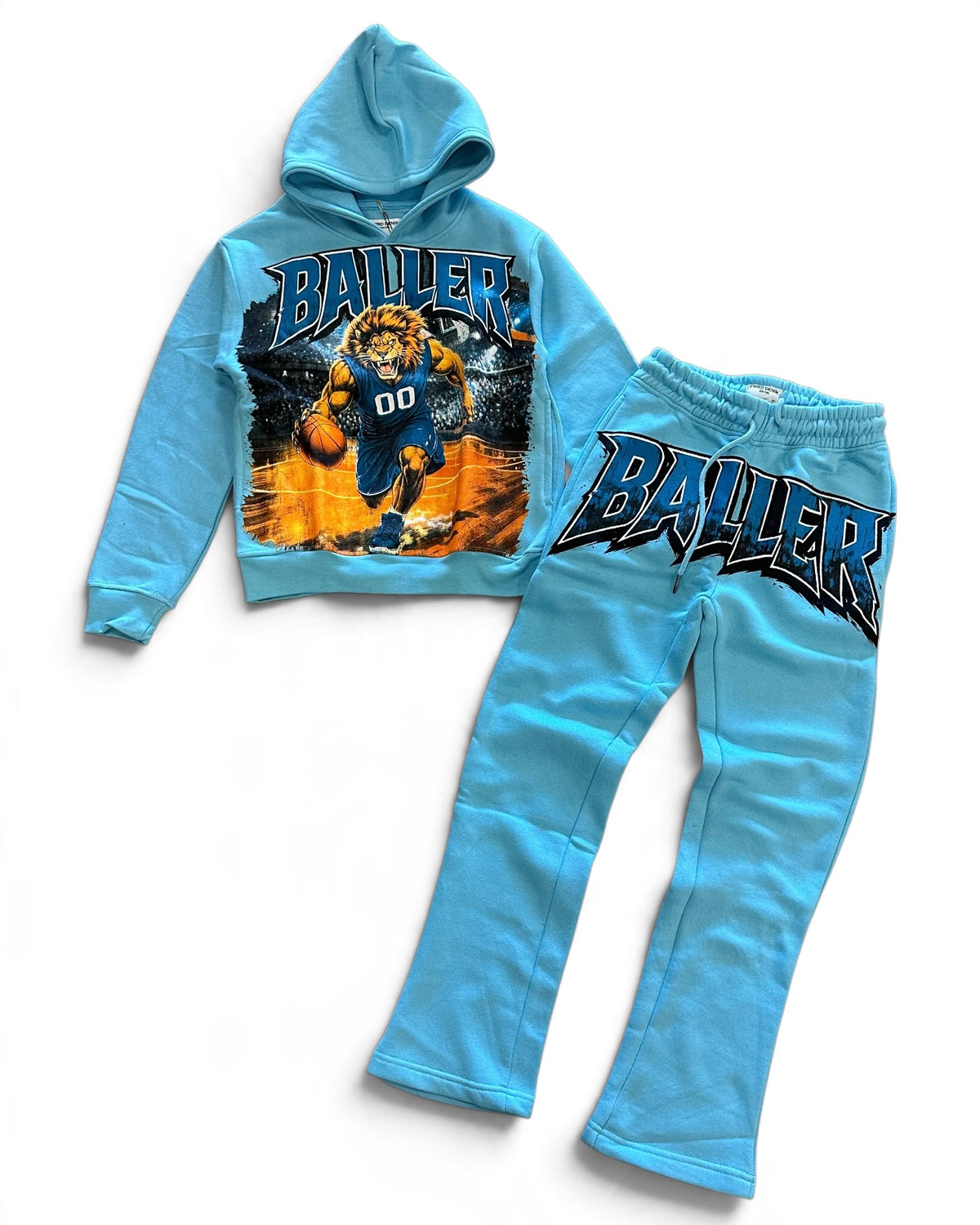 A two-piece kids' sweatshirt and jogger set in light blue, featuring a graphic hoodie with a basketball player and the word 'BALLER' on the front, and matching jogger pants with 'BALLER' printed across the thigh.