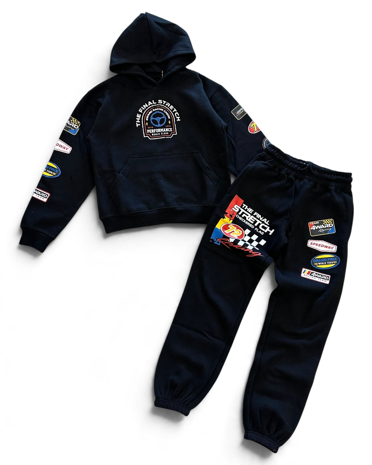A two-piece kids' racing team hoodie and sweatpants set in dark navy blue. The hoodie features a chest graphic and various sponsor patches on the sleeves.
