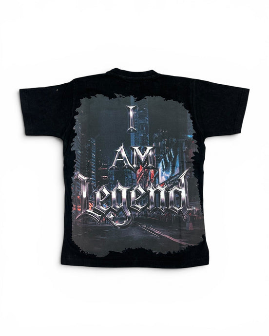 A black short-sleeve graphic t-shirt featuring a large back print with the text 'I AM Legend' in a stylized metallic font over a dark futuristic city scene.