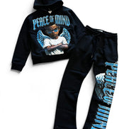 A two-piece kids' tracksuit set consisting of a black cropped hoodie with a 'Peace of Mind' angel graphic and matching black sweatpants featuring a large vertical graphic on the leg, laid out on a white background.