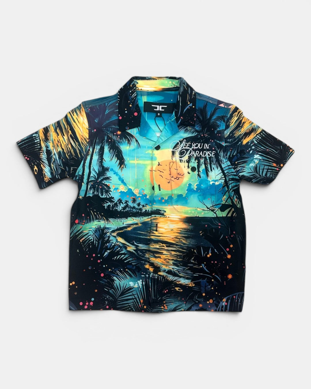 Tropical themed shirt with palm trees and sunset design on a white background