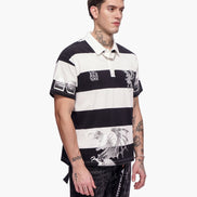 Man wearing a black and white striped polo shirt with graphic designs on a white background