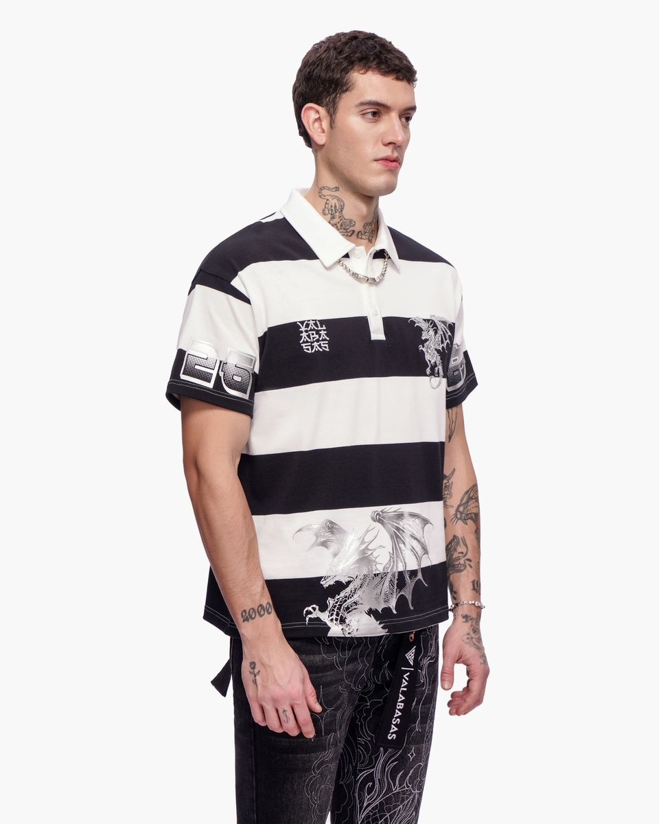 Man wearing a black and white striped polo shirt with graphic designs on a white background