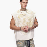 Man wearing a white sleeveless top with gold patterns and camouflage pants on a white background