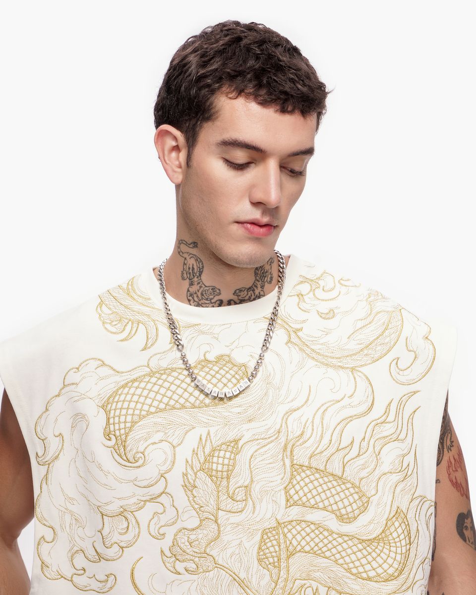 Man wearing a white sleeveless shirt with gold dragon design and a chain necklace on a white background