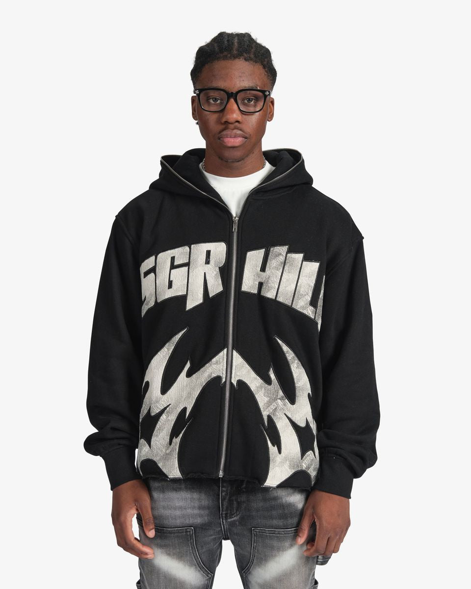 Person wearing a black hoodie with 'SGR HIL' branding on a white background