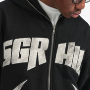 Person wearing a black hoodie with 'SGR HI' printed on it, looking down.